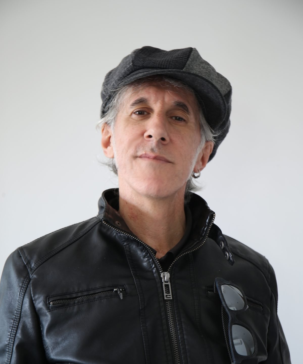 Portrait of Federico De Caroli, the Italian composer who records as Deca, in a dark flat cap and black leather jacket